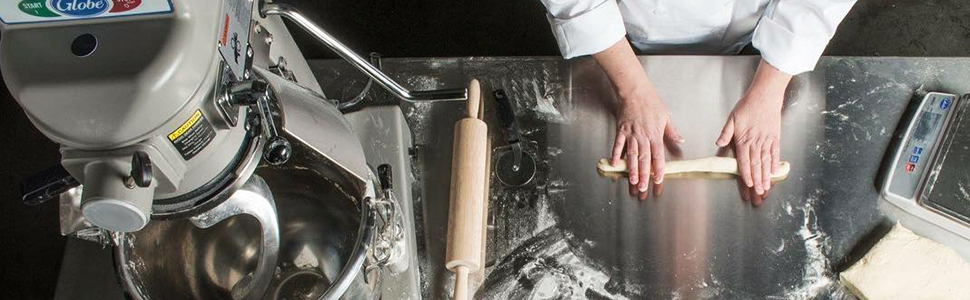 Chef rolling out dough next to Globe® bench stand mixer