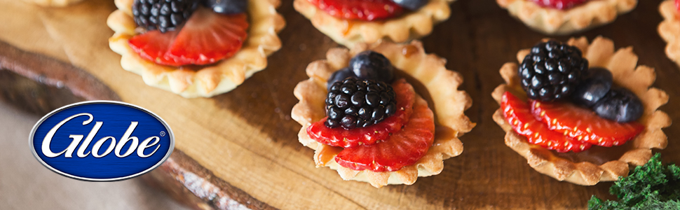 Small tartelettes with berries on wooden cutting board