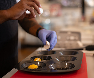 Cracking an egg into a pan tray