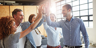 A group of professional standing together and giving each other high-fives