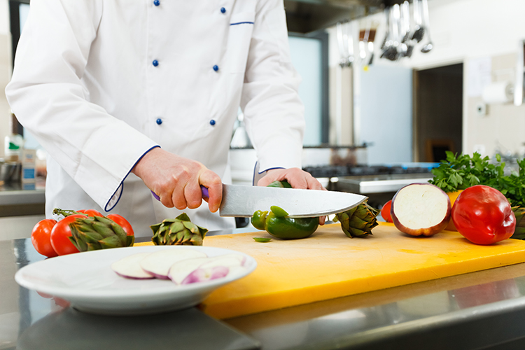 Chef prepping vegetables on cutting board