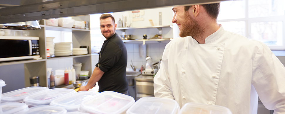 Chef and cook cooking food at restaurant kitchen