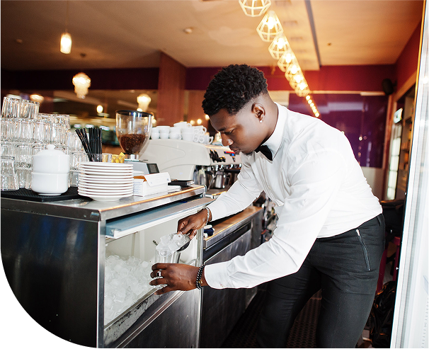 Restuarant employee retrieving ice from an ice machine