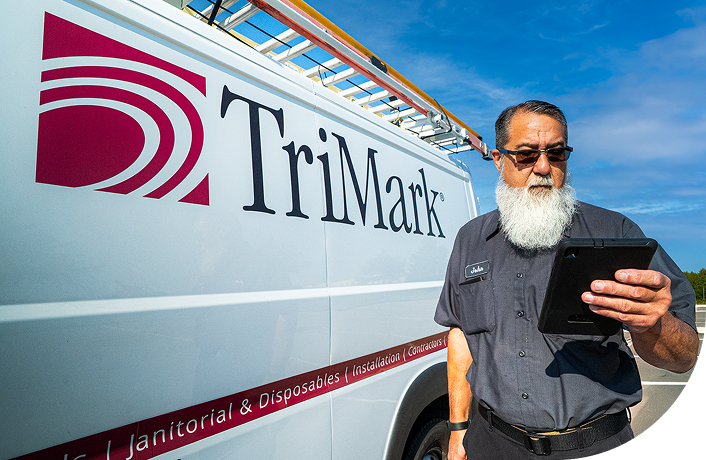 TriMark employee standing next to a repair truck